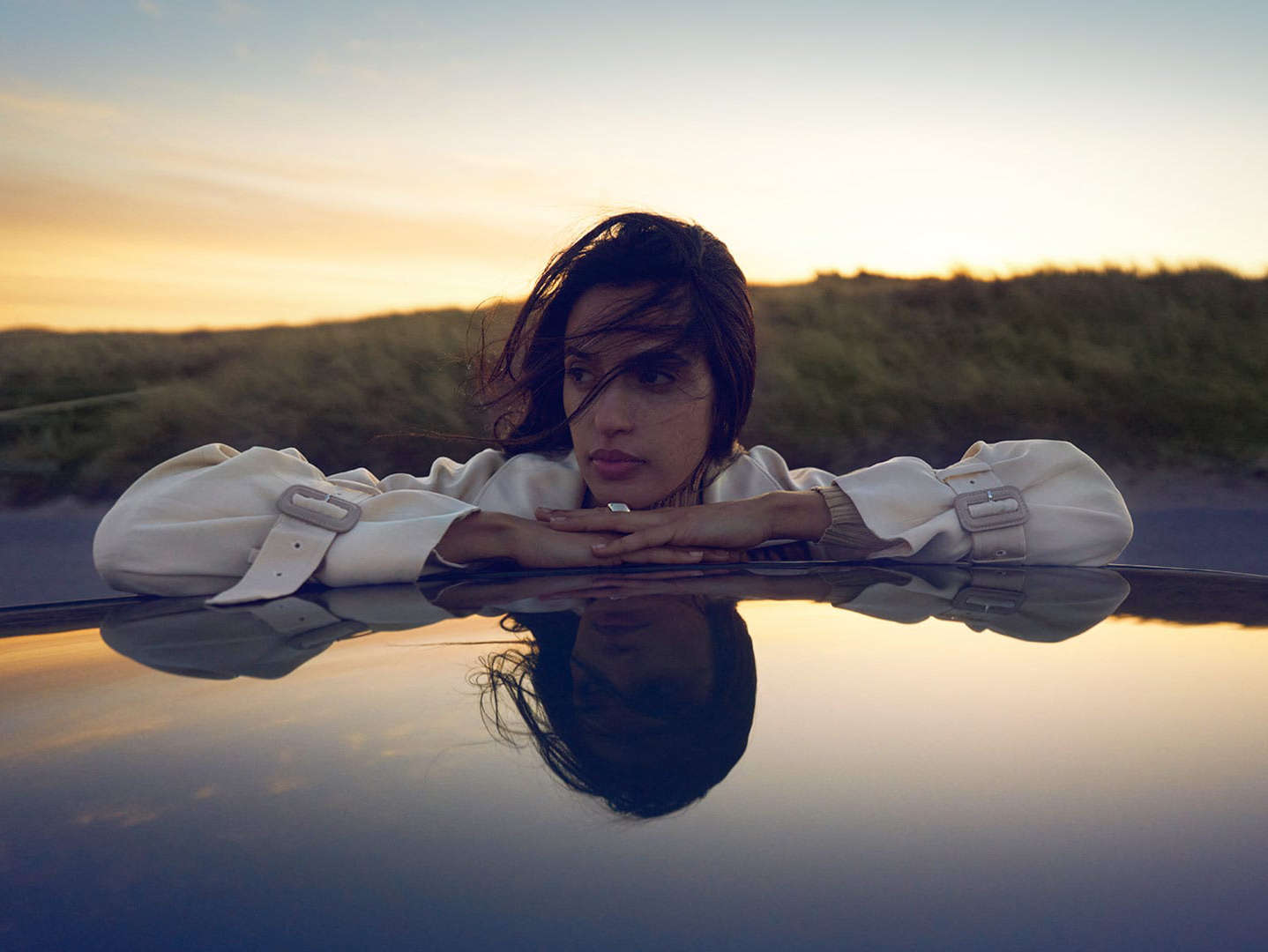 Дівчина обперлася ліктями об дах автомобіля Peugeot